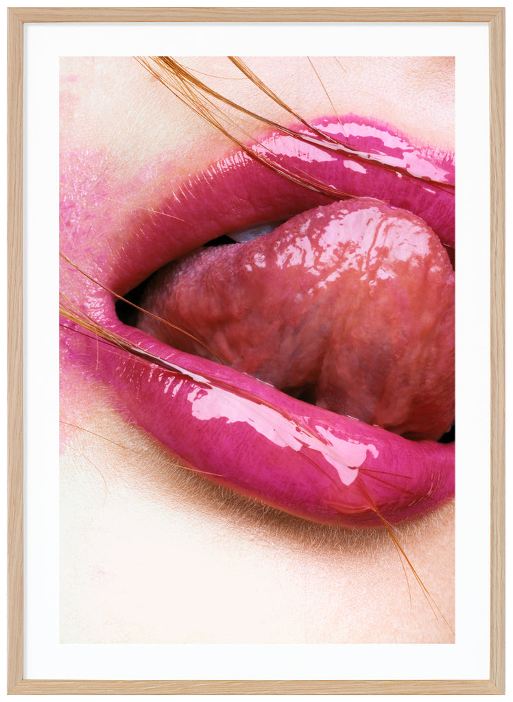 Photograph of close-up of pink lips licking on upper lip.  Oak frame.