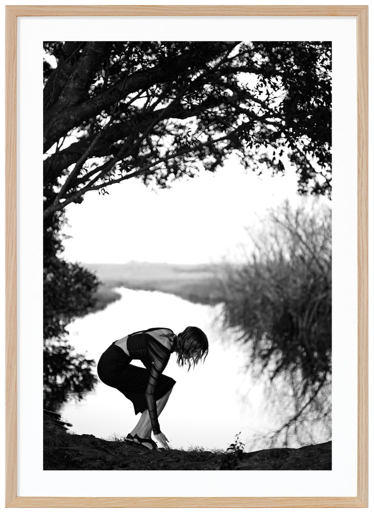 Black and white photograph of a woman under a tree with water in the background. Oak frame. 