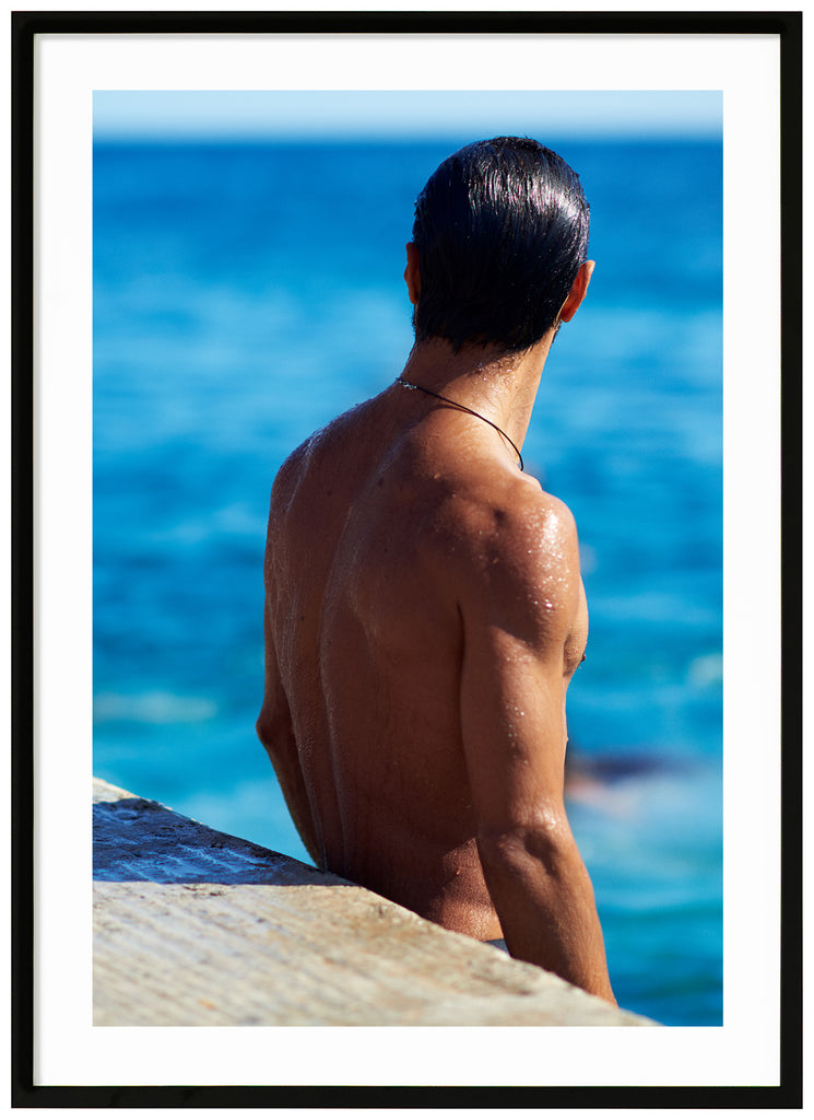 Poster of a man's naked backboard by the sea. Portrait format. Black frame. 
