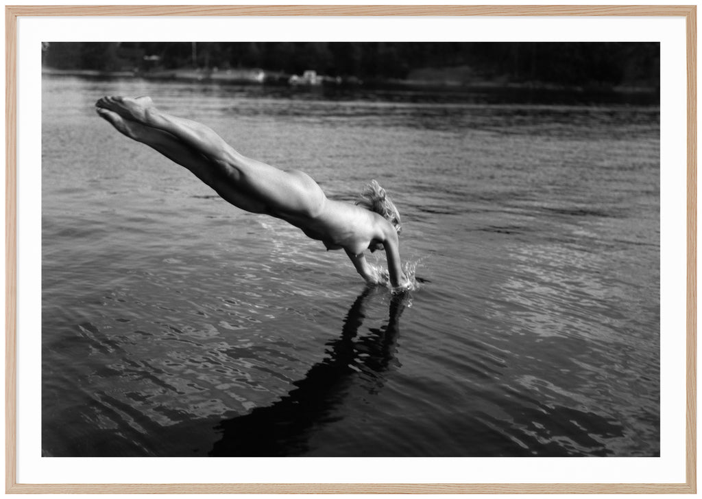 Analogous photograph in black and white, of a naked woman diving into the water. Oak frame. 