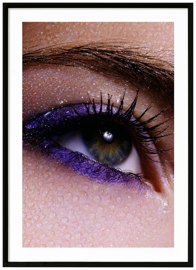 PeepPosts of close-up of eye and eyebrows with purple makeup and water drops over the skin. Black frame. 