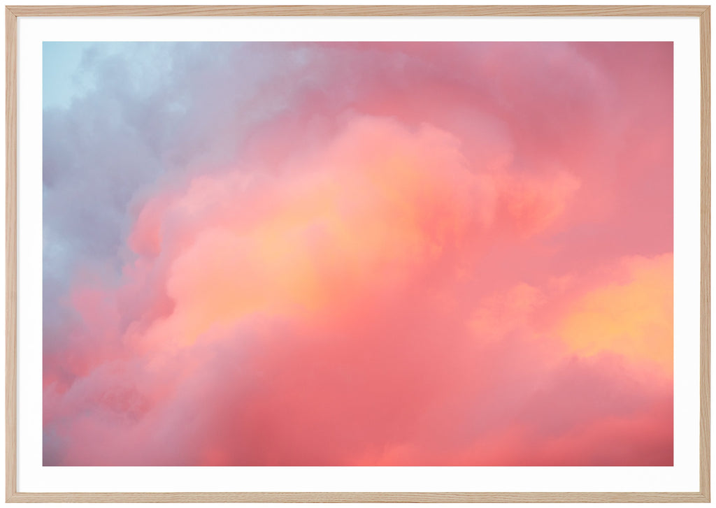Color photograph of clouds in blue, pink, purple, orange. Horizontal format.  Oak frame. 