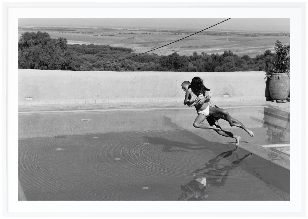 Love couple throwing themselves in a pool. Taken in Morocco by Patrik Sehlstedt.  White frame. 