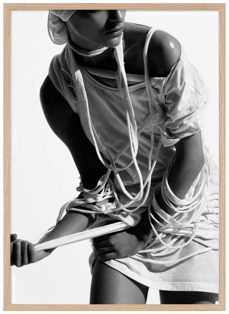Black and white poster of woman with torn clothes. Oak frame. 