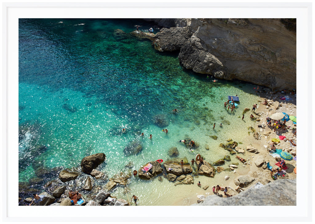 Color photography of a beach and cliffs in southern Italy. White frame.