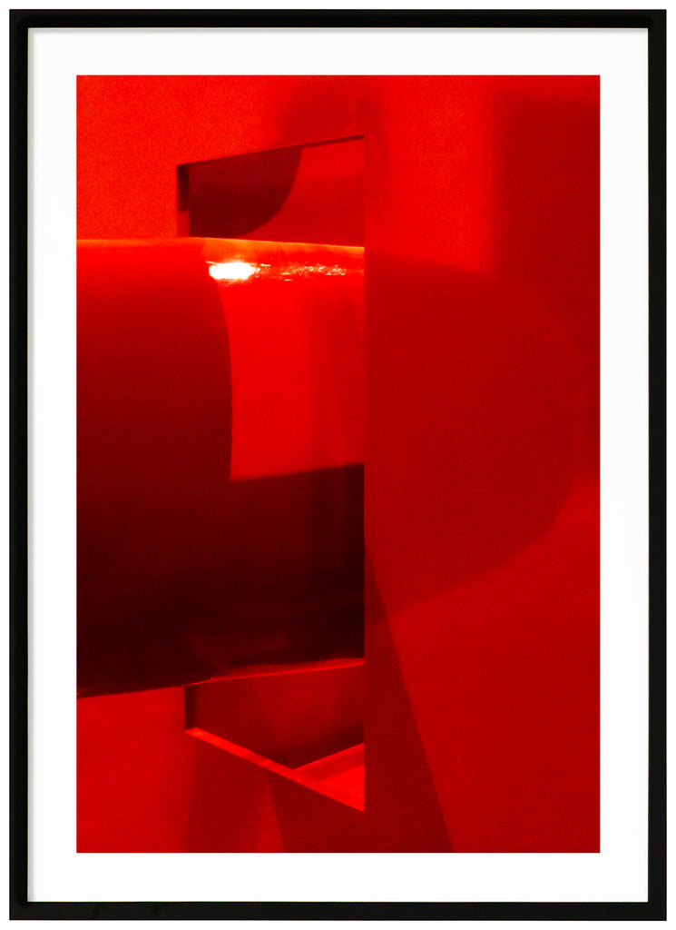 Red abstract print with a white surface around. Black frame.