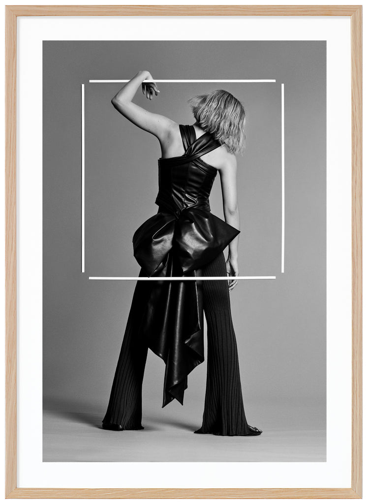 Black and white poster of woman seen from behind in photo studio. Oak frame. 