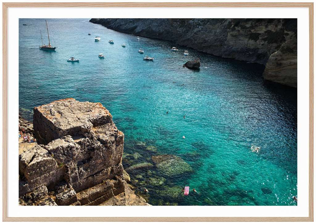 Photograph of cliffs, boats and the light blue Adriatic Sea in southern Italy. Oak frame. 