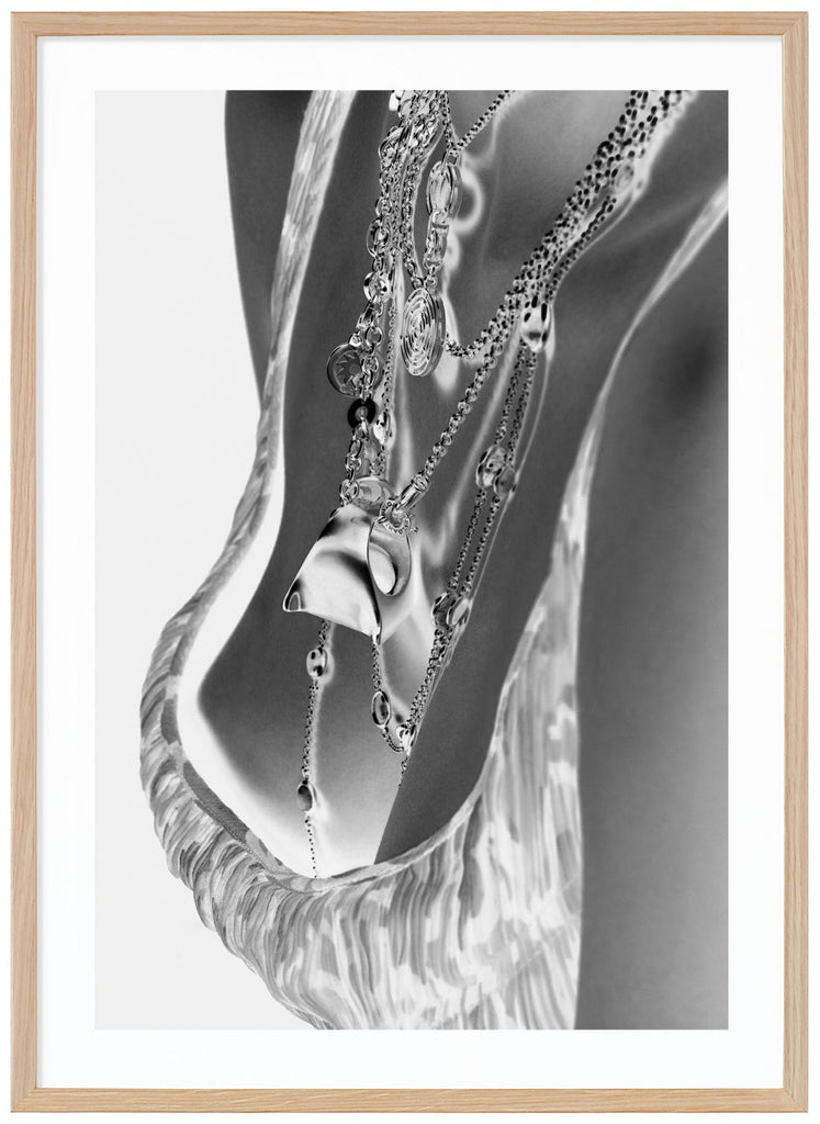 Black and white photograph of female breasts with exclusive necklaces. Oak frame. 