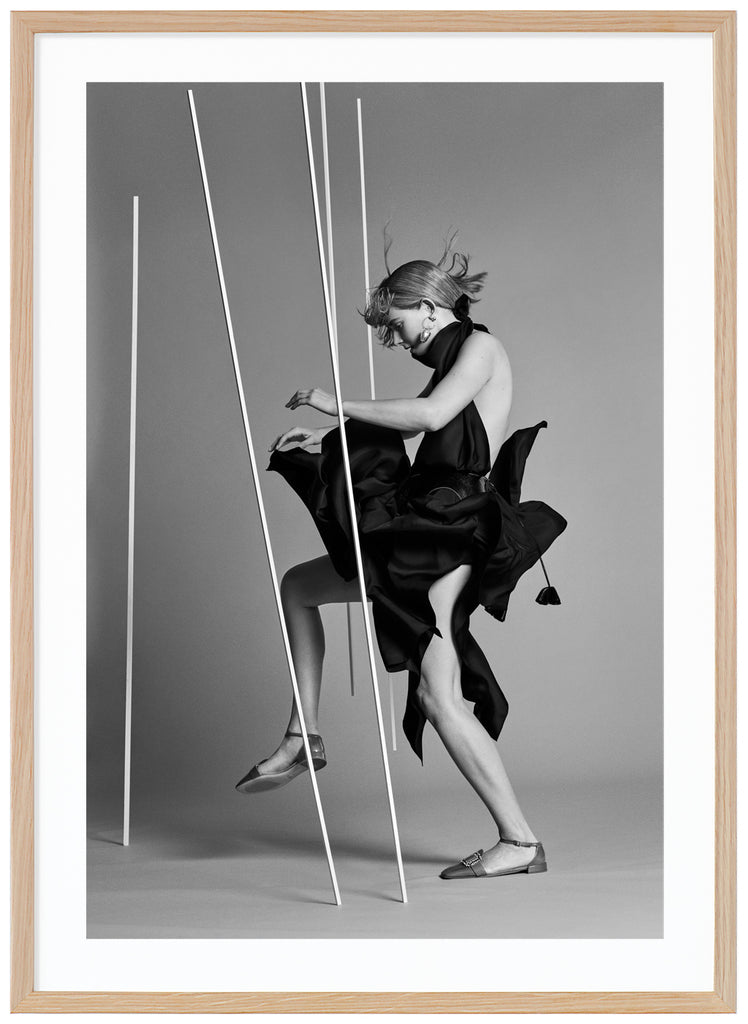 Black and white poster of woman wearing black seen from the side in photo studio. Oak frame. 