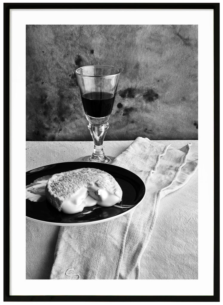 Still life of a french cheese and a glass of red wine. Black frame.