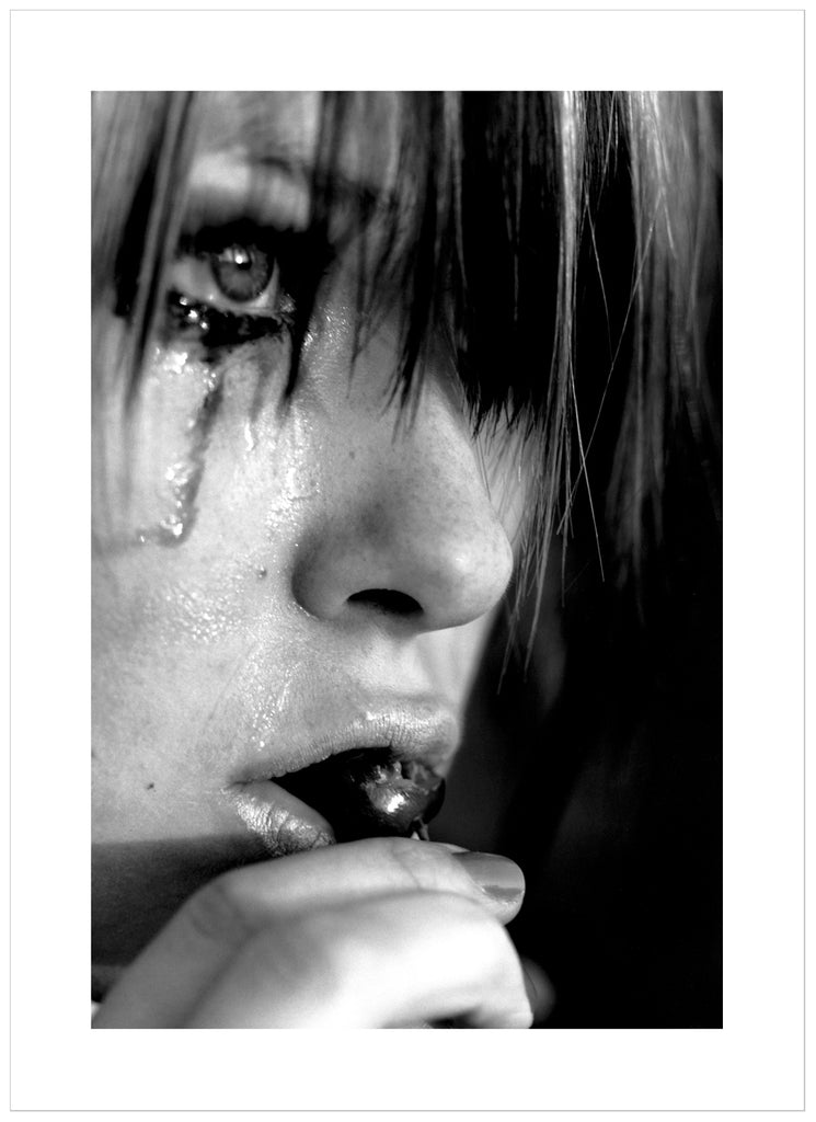 Black and white posters. Close-up of person crying and eating cherries.