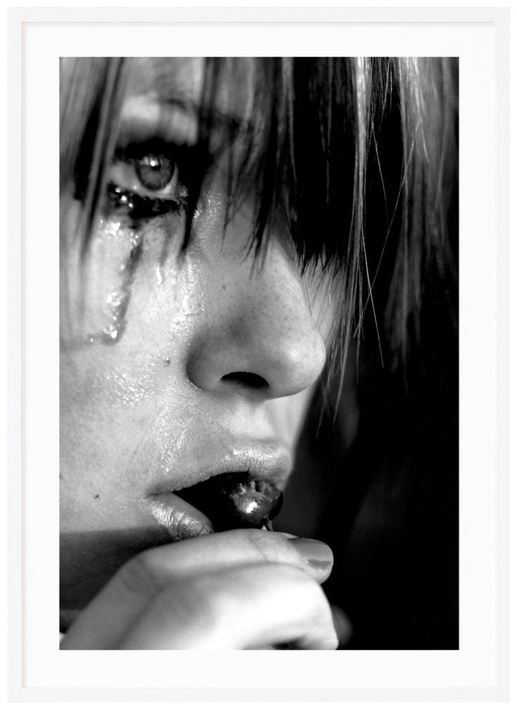 Black and white posters. Close-up of person crying and eating cherries. White frame. 