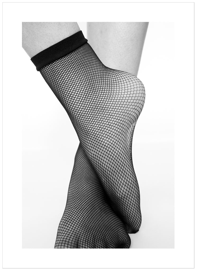 Black and white posters. Close-up of feet in fishnet stockings.