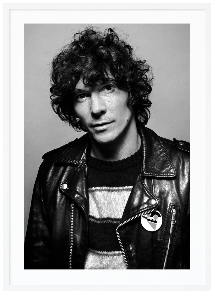 Photograph of Håkan Hellström wearing a black leather pie. White frame. 