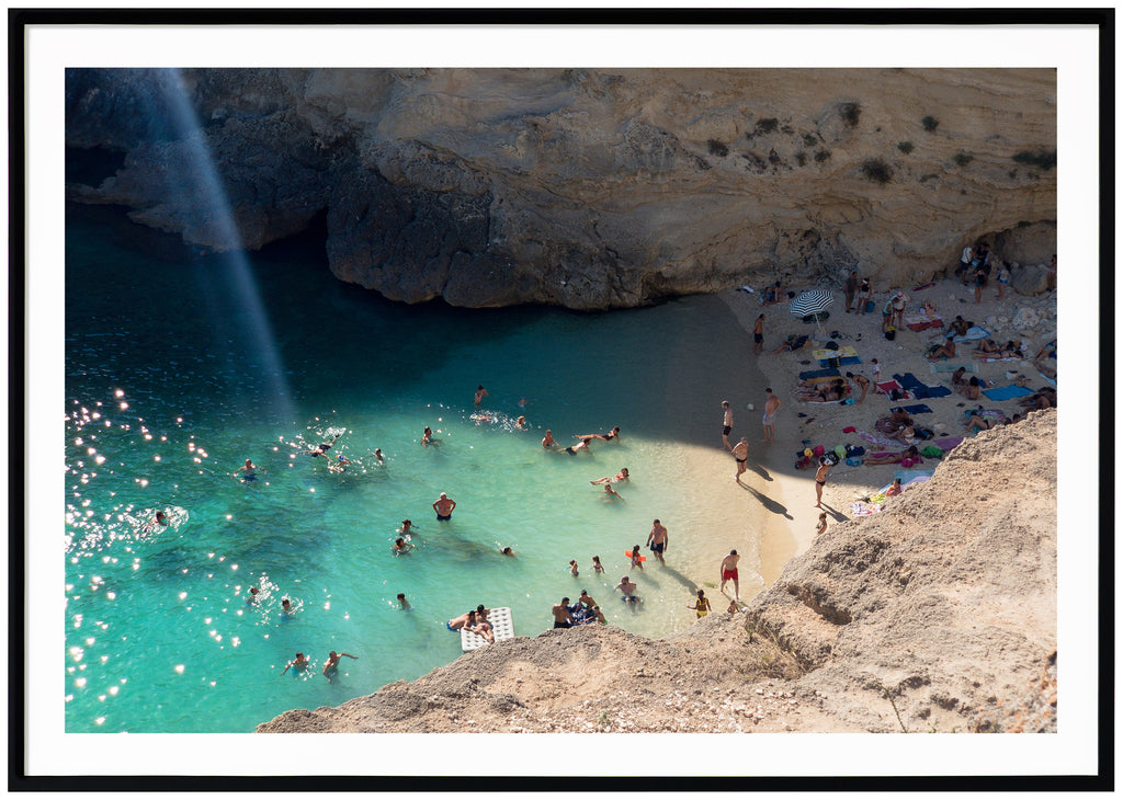 Posts of bathing place by rocks. Sparkling water. Landscape format. Black frame. 