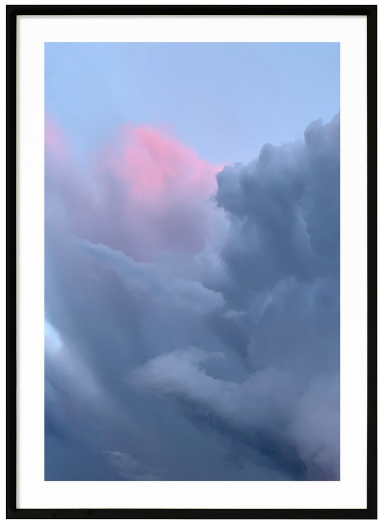 Poster of clouds in blue-gray tones and a light pink hue. Black frame. 