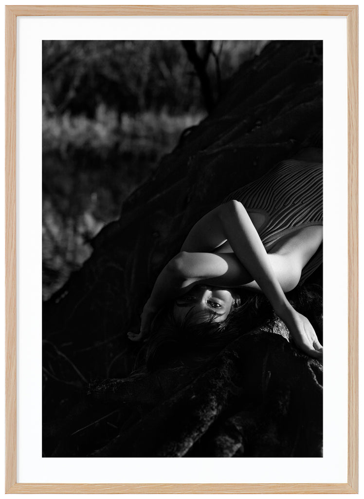Black and white poster of woman lying on a tree. Oak frame. 