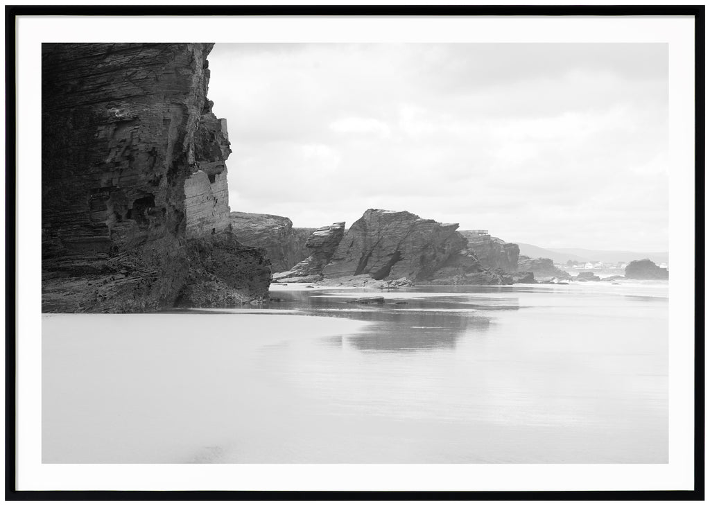 Black and white items of rocks by the beach. Black frame. 