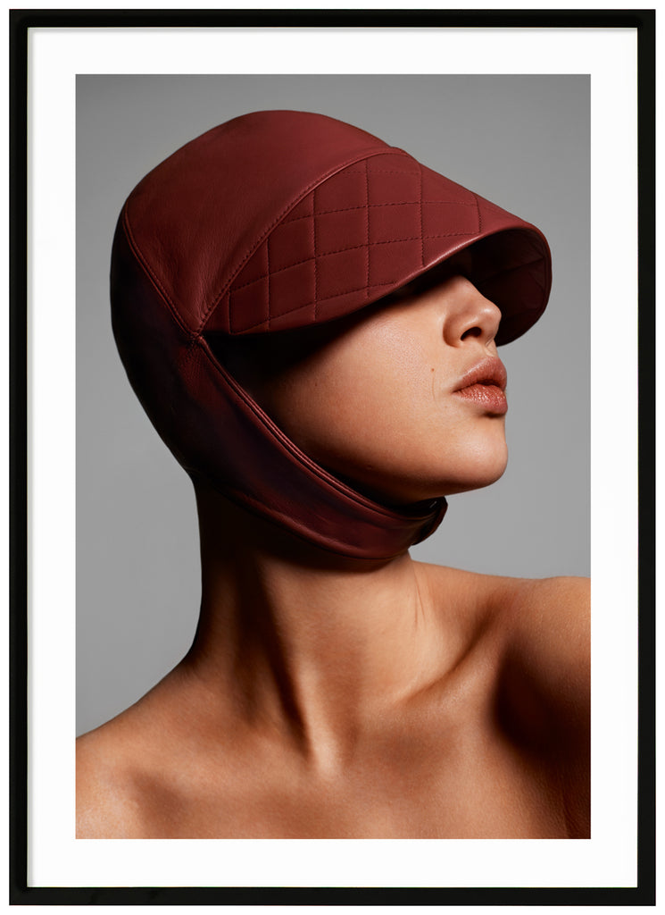 Poster of close-up of woman with leather hat. Black frame. 