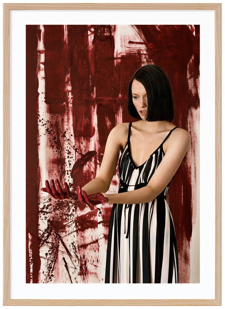 Woman standing in front of an abstract work of art.  Oak frame. 