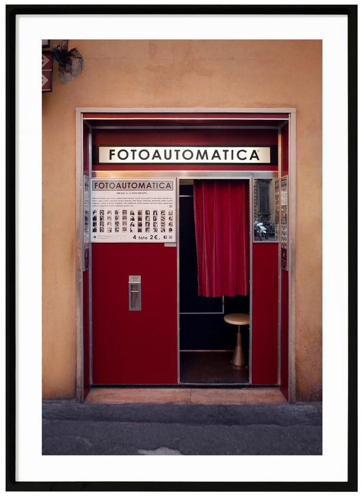 Photography of an old photo booth located in a wall in an Italian city. Black frame. 