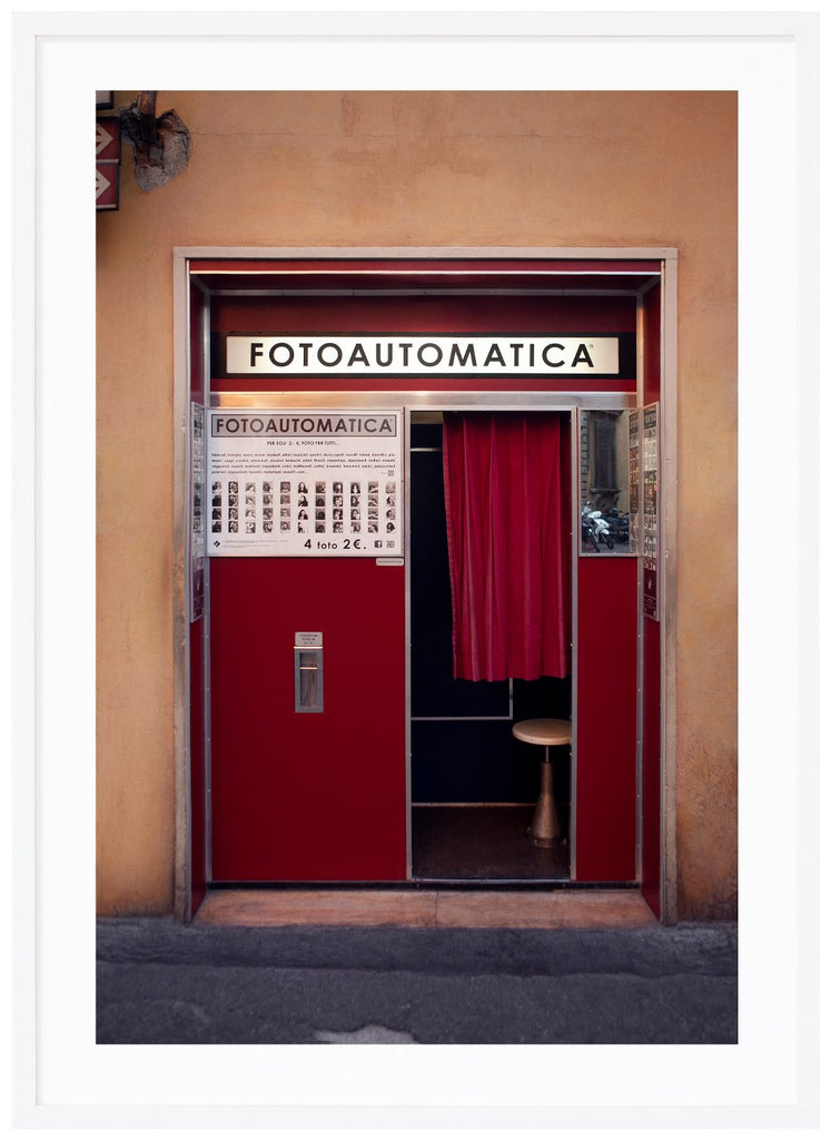 Photography of an old photo booth located in a wall in an Italian city.  White frame. 