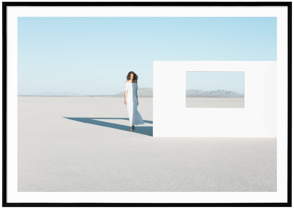 Photography of a woman in white dress in the Mojave Desert, California. Black frame. 