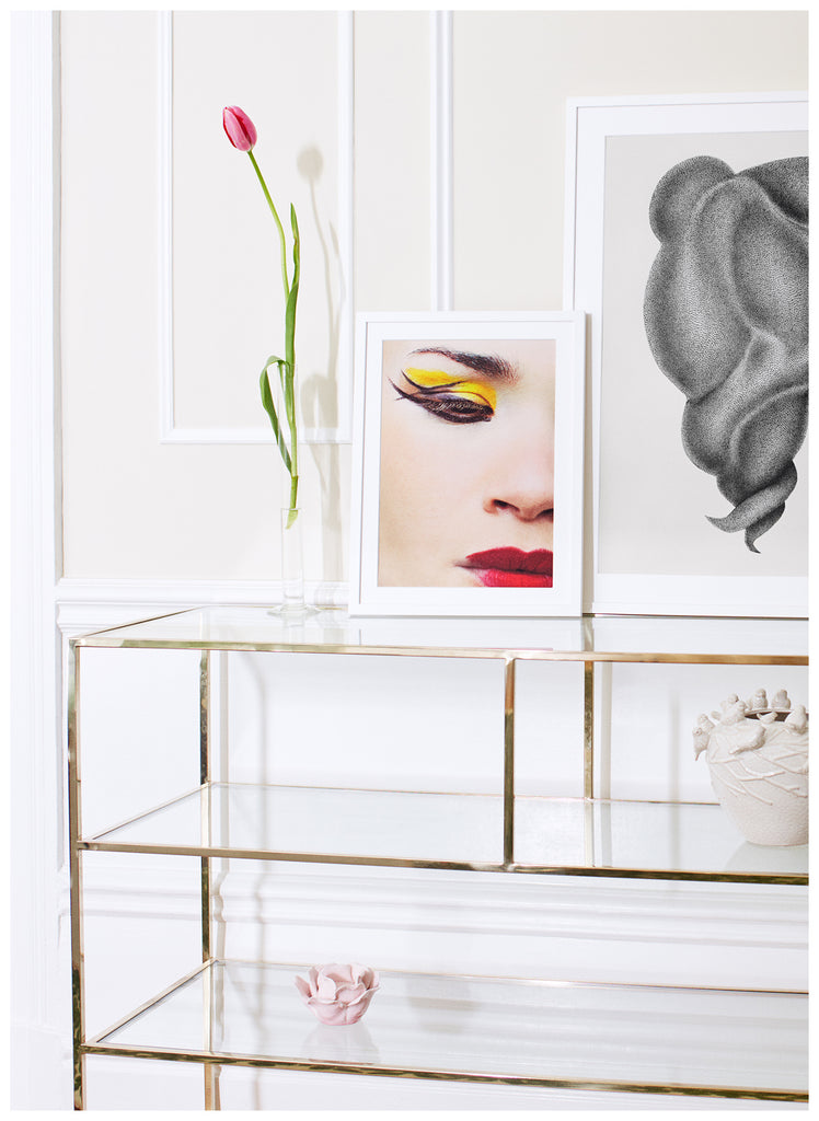 photograph of close-up of woman with make-up in yellow, red and black. White frame.