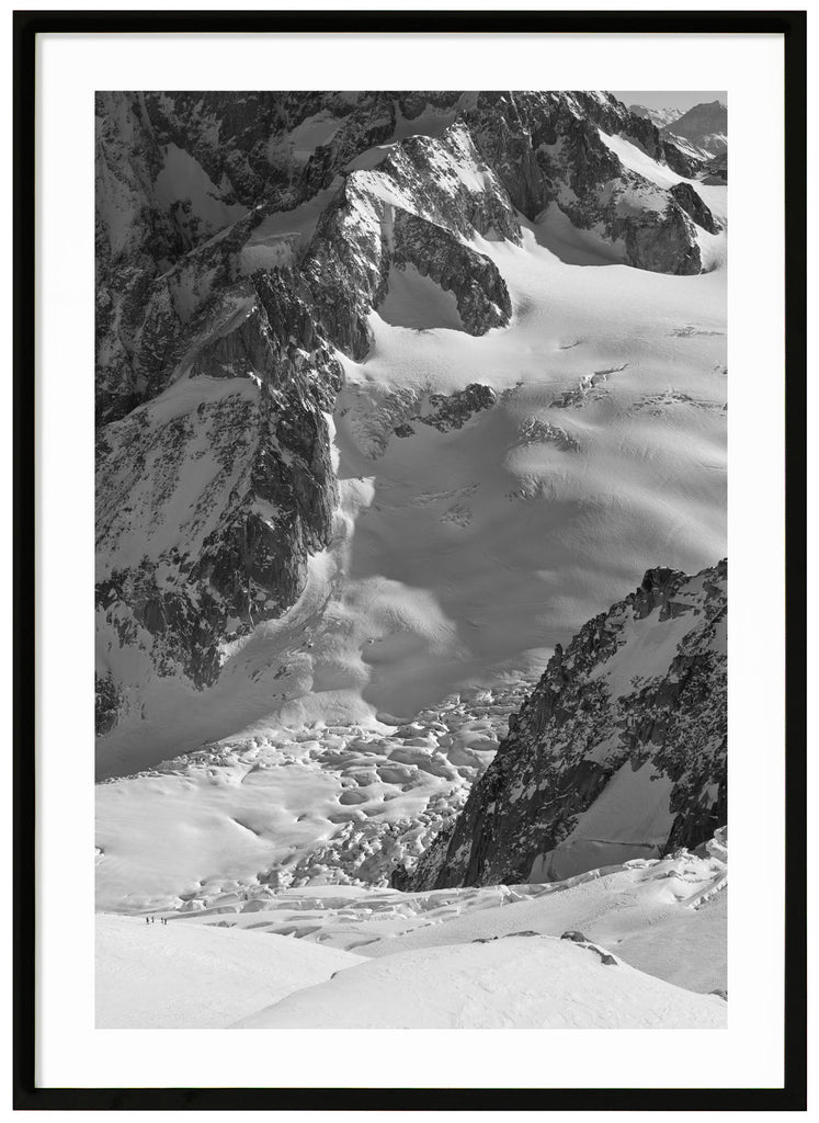 black and white items of sun-drenched snow cover over the mountains of the Alps. Black frame. 