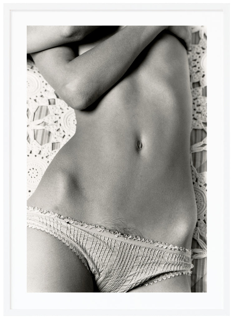 Analogous photograph of a woman lying on her back in panties and embracing her breasts. White frame. 