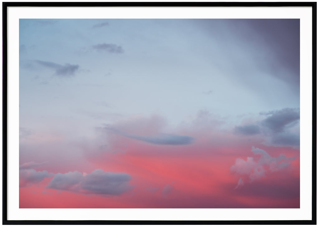 Photograph of clouds in red and blue light. Black frame. 