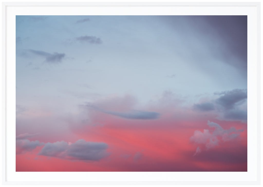 Photograph of clouds in red and blue light. White frame. 