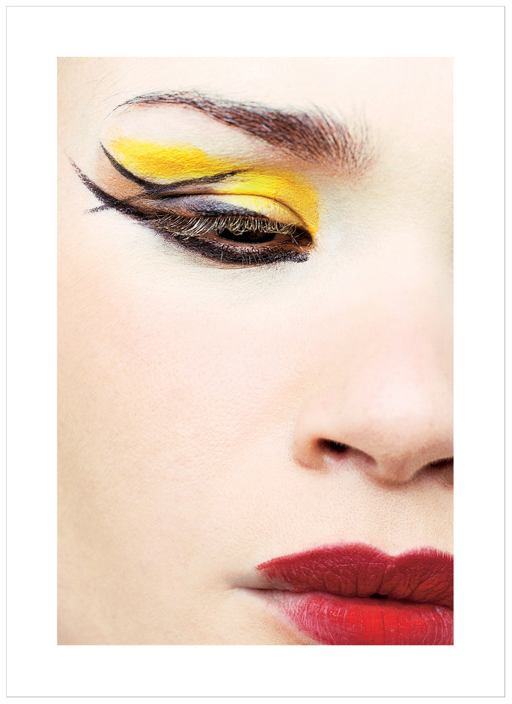 photograph of close-up of woman with make-up in yellow, red and black.