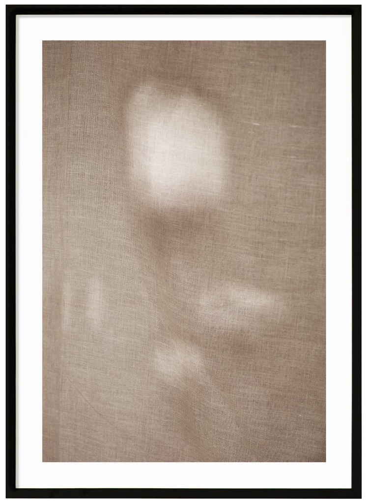 Photographic art of fabric moving in the wind with a beautiful play of light that appears in patches. Black frame. 