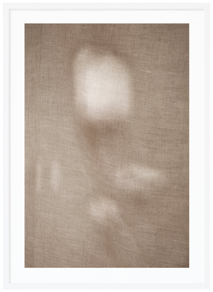 Photographic art of fabric moving in the wind with a beautiful play of light that appears in patches. White frame. 