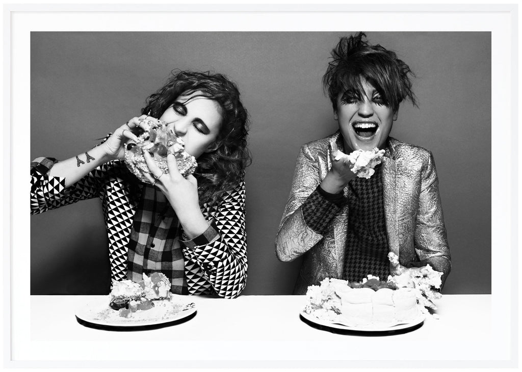 Black and white poster of icona pop eating cake.Black and white poster of icona pop eating cake. White frame. 