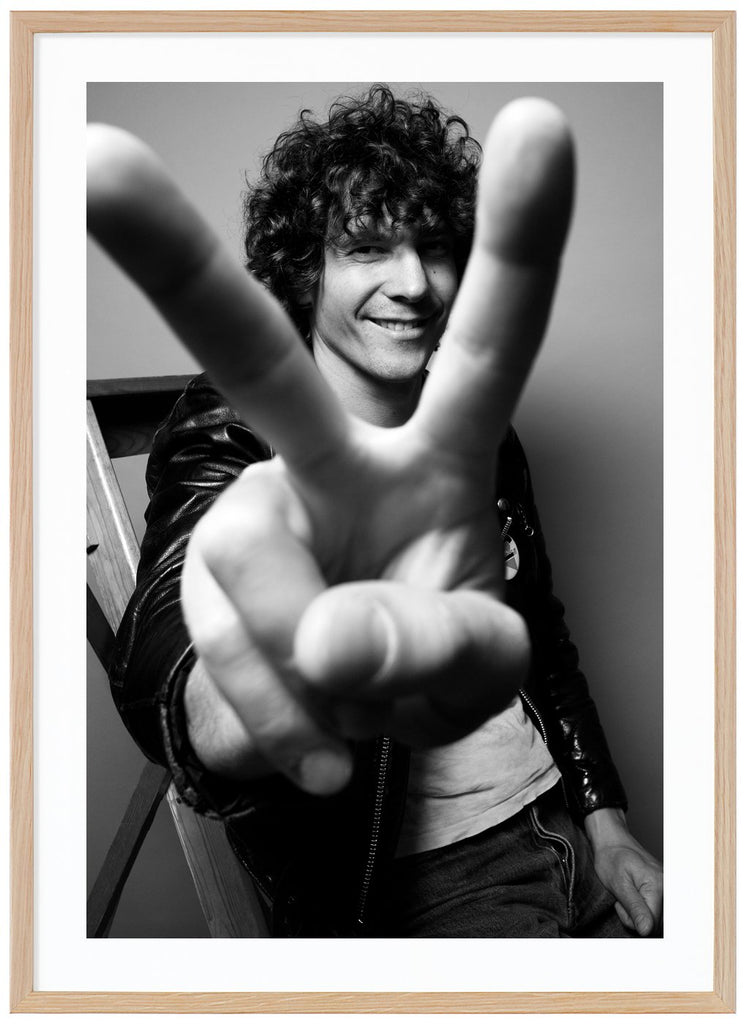 We see our Håkan holding up a peace sign with his fingers in front of the camera. Oak frame. 
