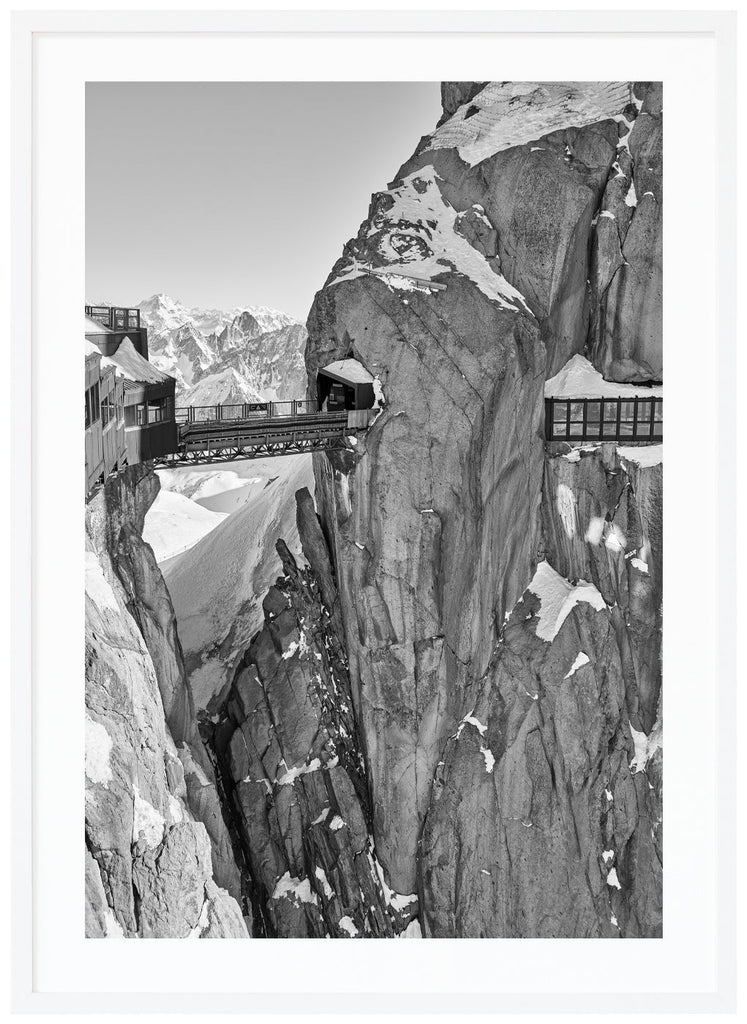 The dramatic view of the bridge atop the Aiguille du Midi in the French Alps. White frame. 