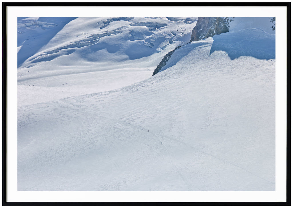 Color photography of a huge snow-covered surface, taken in the French Alps.  Black frame. 