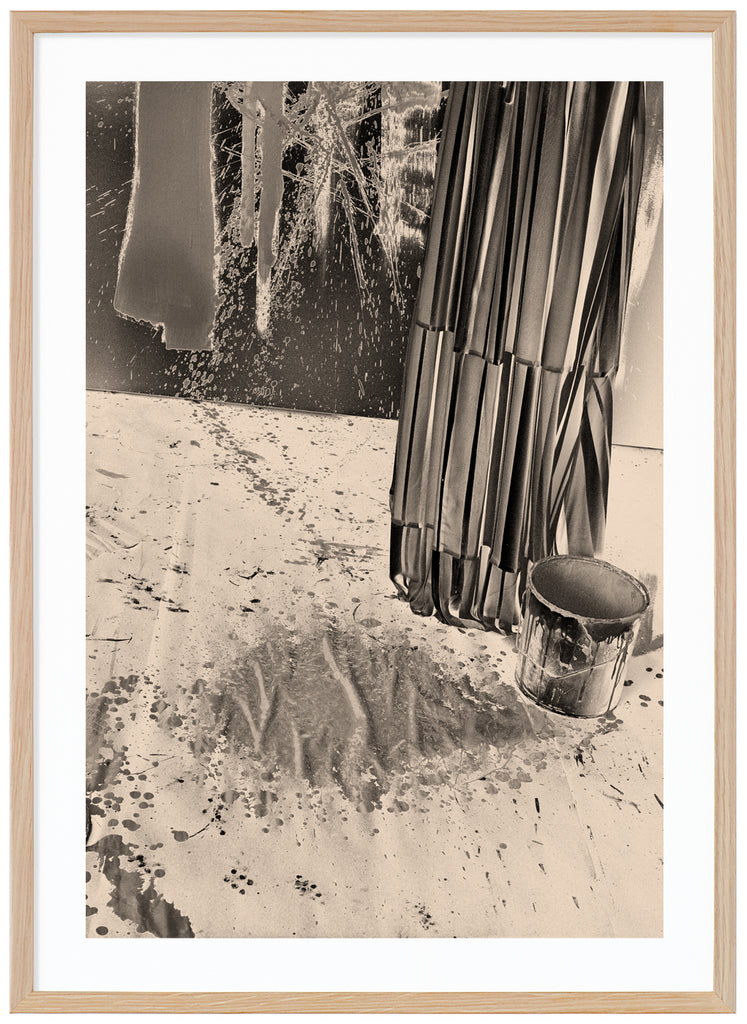 Monochrome photography in a warm tone of a paint bucket and paint splashes on the wall.  Oak frame. 