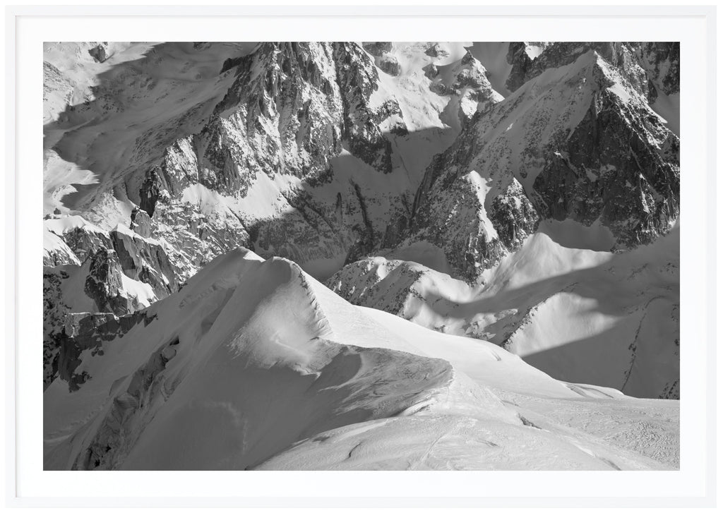Black and white photograph of snow-capped Alps. White frame. 