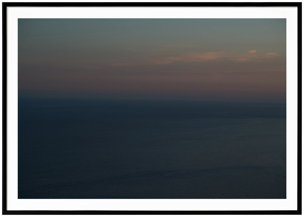 At one of many sunsets on the Amalfi Coast in Italy, which make the sky light blue, orange and pink. Black frame. 