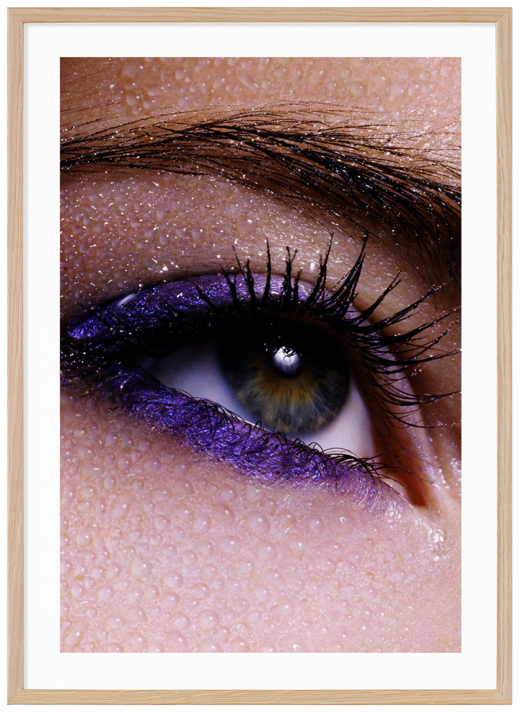 Posts of close-up of eye and eyebrows with purple makeup and water drops over the skin. Oak frame. 