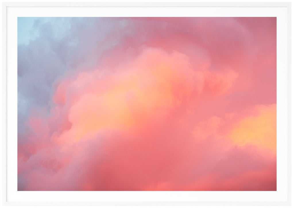 Color photograph of clouds in blue, pink, purple, orange. Horizontal format.  White frame.
