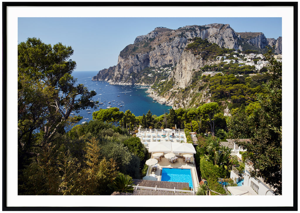Horizontal photography in color view of a swinging pool and mountains on the island of Capri in Italy.  Black frame. 