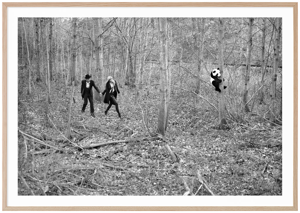 Analogous black and white photograph of a couple discovering a panda in a forest.  Oak frame. 