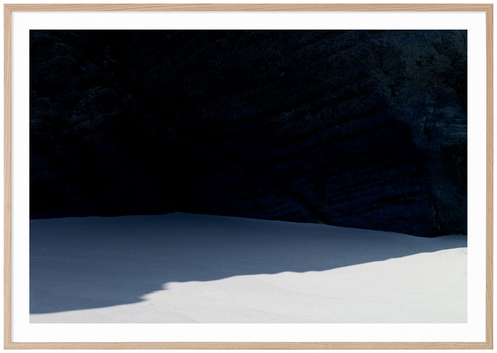  Graphic photograph of a beach with a shadow from a dark cliff.  Oak frame. 