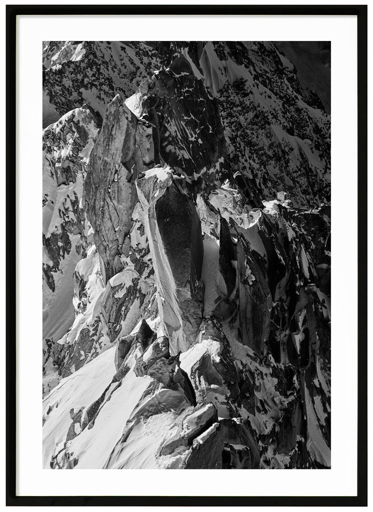 Black and white photograph of sharp cliffs in the Alps. Black frame. 