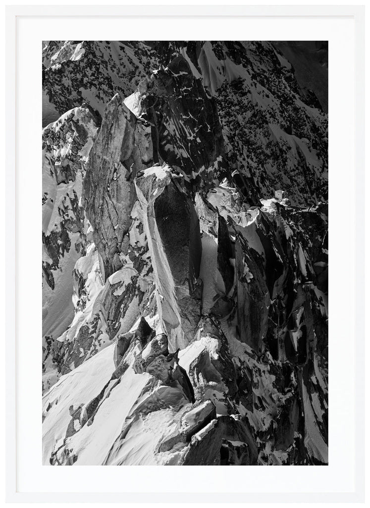 Black and white photograph of sharp cliffs in the Alps. White frame.